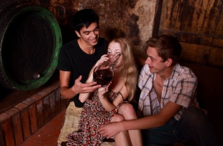 Young blonde has sex with a couple of boys while they drink wine in a cellar 16407469