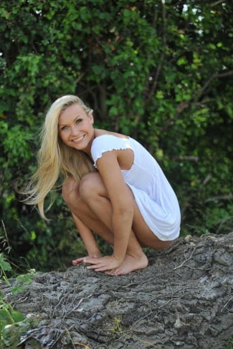 Blonde girl Michaela shows her bare ass after getting naked in a field 21011495