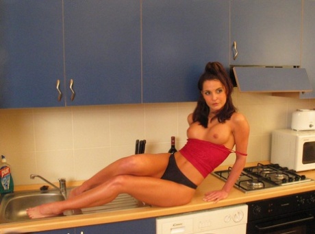 Amateur model Susy Rocks exposes her enhanced tits in a kitchen 71895653