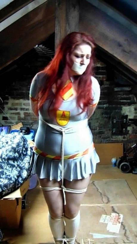 Redheaded plumper Mada Rose is tied to an attic post while clothed and gagged 31834038