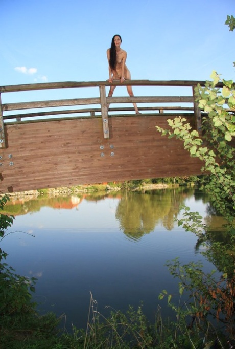 Brunette teen Lady Cate gets totally naked on a bridge over the water 13924508